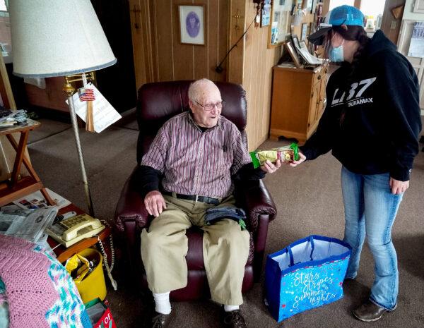 Emerson Kennedy receives a gift from Rebecca Collings of the Veterans Esteem Team near Cass City, Mich., on Dec. 28, 2021. (Steven Kovac/Epoch Times)