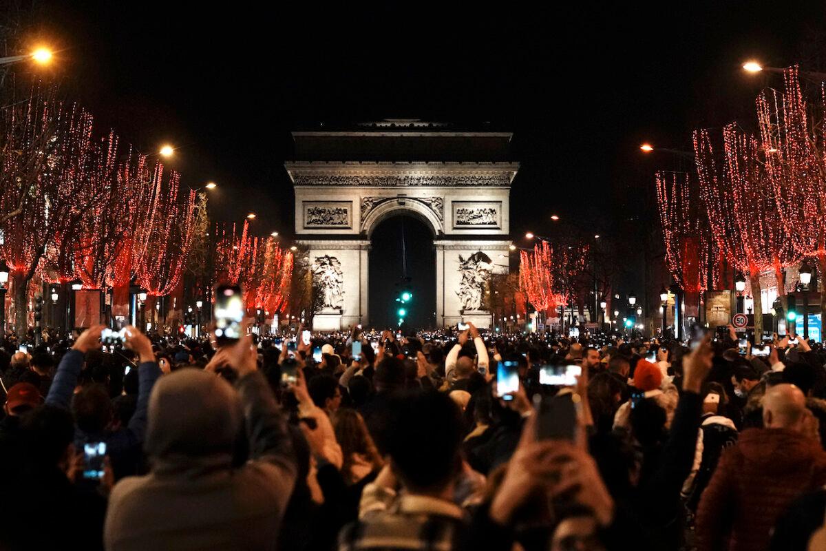 People celebrate New Year's Eve on Champs Elysees avenue, in Paris, on Dec. 31, 2021. (Thibault Camus/AP Photo)