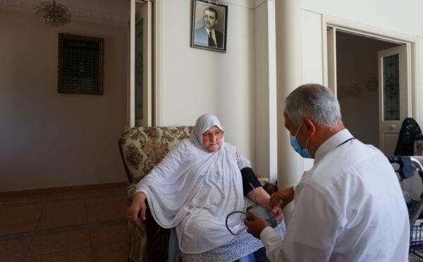 Dr. Jamal Rifi performs a routine health check at home with Hagge Amine in Sydney, Australia, on Oct. 3, 2021. (Lisa Maree Williams/Getty Images)