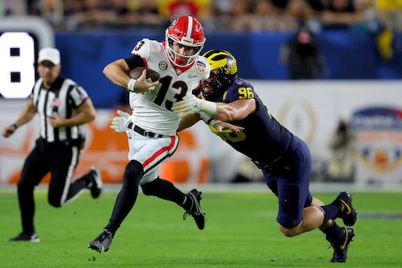 Stetson Bennett #13 of the Georgia Bulldogs runs with the ball as Julius Welschof #96 of the Michigan Wolverines defends in the second quarter of the Capital One Orange Bowl for the College Football Playoff semifinal game at Hard Rock Stadium, in Miami Gardens, Fla., on Dec. 31, 2021. (Kevin C. Cox/Getty Images)