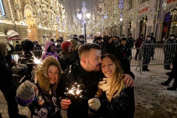 People celebrate the New Year in Nikolskaya street near an empty Red Square due to pandemic restrictions during New Year celebrations in Moscow, Russia, on Jan. 1, 2022. (Alexander Zemlianichenko Jr/AP Photo)