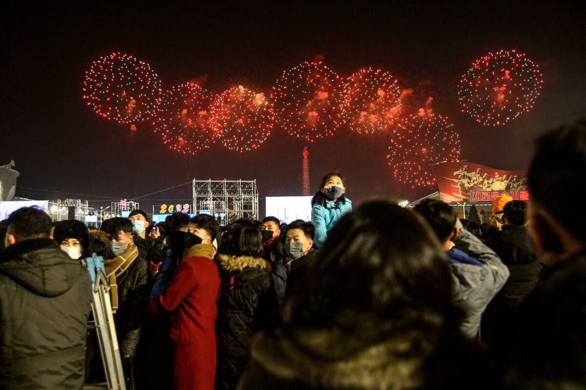 People gather to watch a fireworks display to celebrate the New Year on Kim Il Sung Square in Pyongyang on Jan. 1, 2022. (Kim Won Jin/AFP via Getty Images)