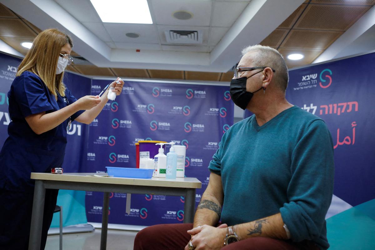 A medical worker prepares to give a man a fourth dose of a COVID-19 vaccine, at Sheba Medical Center in Ramat Gan, Israel, on Dec. 31, 2021. (Nir Elias/Reuters)