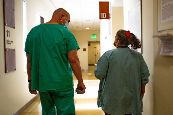 Hospital staff members walk down a hall in Orange, Calif., on Dec. 16, 2020. (John Fredricks/The Epoch Times)