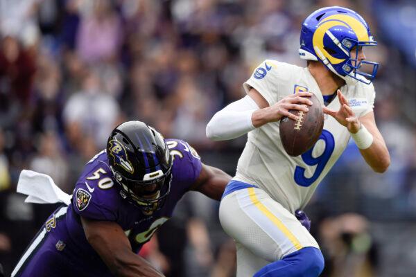 Los Angeles Rams quarterback Matthew Stafford (9) dodges a sack attempt by Baltimore Ravens outside linebacker Justin Houston (50) during the first half of an NFL football game, in Baltimore, on Jan. 2, 2022. (Gail Burton/AP Photo)