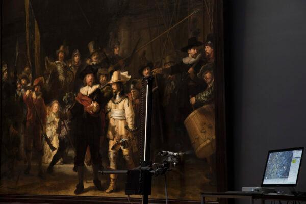 A microscopic image enlarging a 4×6 millimeter part of the painting on Rembrandt’s “The Night Watch” is seen on a screen next to the painting, at the Rijksmuseum in Amsterdam, Netherlands, on Oct. 16, 2018. (Peter Dejong/AP Photo)