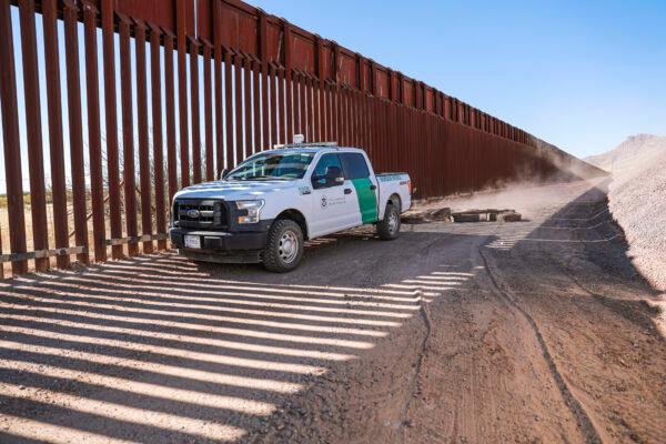 A Border Patrol agent pulls tires behind his vehicle to smooth out the road to make detecting footprints easier, near Naco in Cochise County, Ariz., on Dec. 6, 2021. (Charlotte Cuthbertson/The Epoch Times)