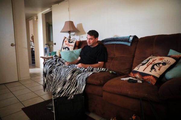 Edward Fritsch sits with the unfinished crochet blanket that his mother was making him, at his home in Benson, Ariz., on Dec. 9, 2021. (Charlotte Cuthbertson/The Epoch Times)