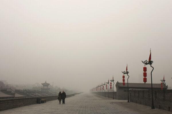 Tourists walk on the city wall as heavy smog engulfs  Xi’an, China on Dec. 18, 2013. (Getty Images)