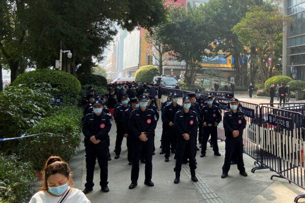  Police officers stand guard outside the Evergrande International Center where protesters have gathered to seek payment from China Evergrande Group, in Guangzhou, Guangdong province, China, on Jan. 4, 2022. (David Kirton/Reuters)