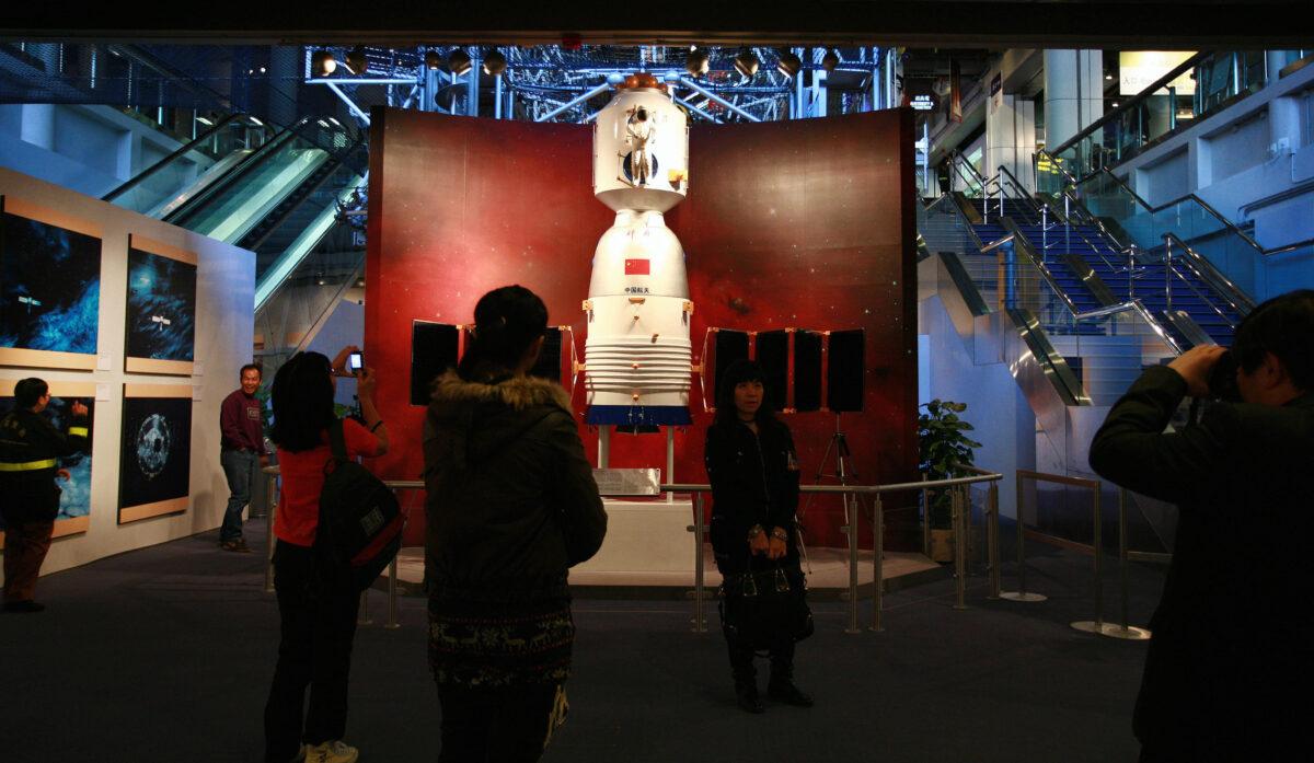 Visitors take photos in front of the Shenzhou-7 spacecraft module during a "China's First Spacewalk Mission" exhibition at the Hong Kong Science Museum on Dec. 6, 2008. (SAMANTHA SIN/AFP via Getty Images)