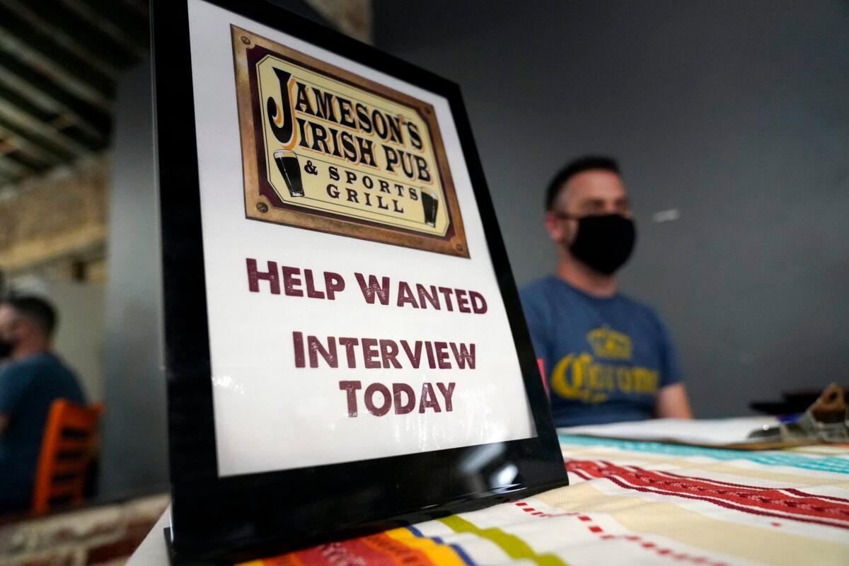 A hiring sign is shown at a booth for Jameson's Irish Pub during a job fair in Los Angeles in a file photograph. (Marcio Jose Sanchez/AP Photo)