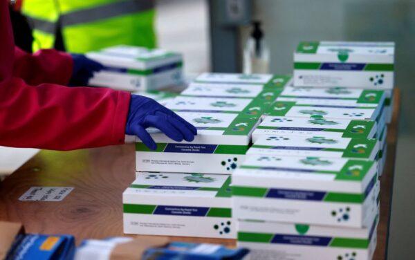 Volunteers hand out Covid-19 rapid antigen Lateral Flow Tests (LFT) boxes in northeast London on January 3, 2022. (Tolga Akmen/AFP via Getty Images)