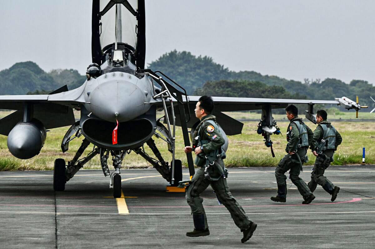Taiwanese air force pilots run pass an armed U.S.-made F-16V fighter jet at an air force base in Chiayi, a city in southern Taiwan, on Jan. 5, 2022. (Sam Yeh/AFP via Getty Images)