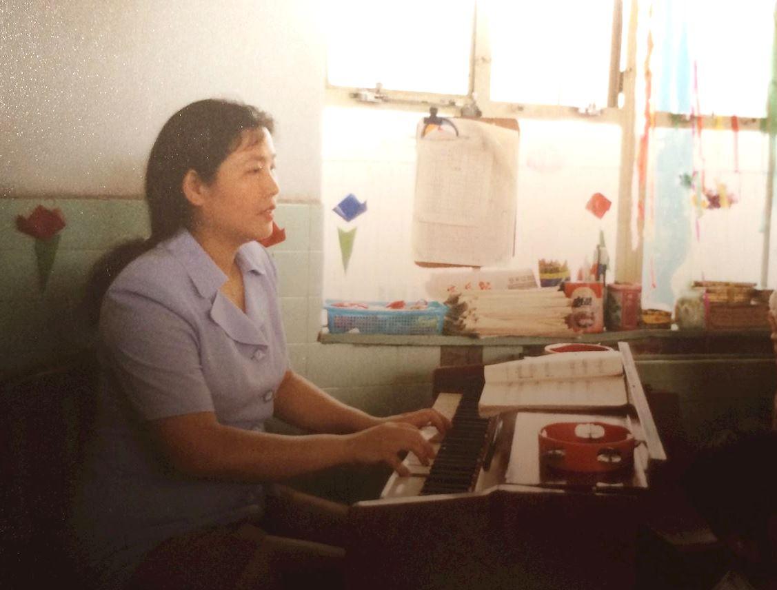An undated photo of Huang Shiqun playing the piano at work. (Courtesy of Minghui.org)