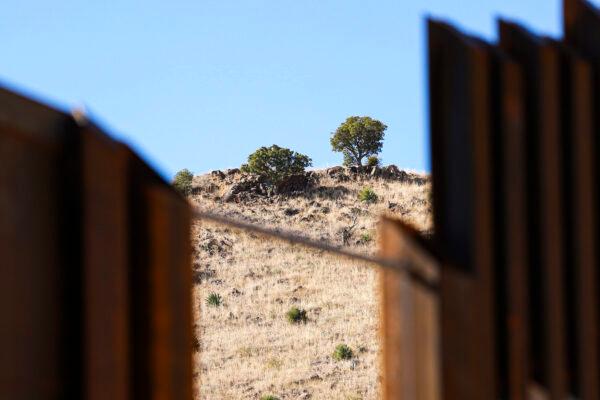 A cartel scout’s campsite can be seen below a tree on the Mexican side of the border wall near Naco in Cochise County, Ariz., on Dec. 6, 2021. (Charlotte Cuthbertson/The Epoch Times)