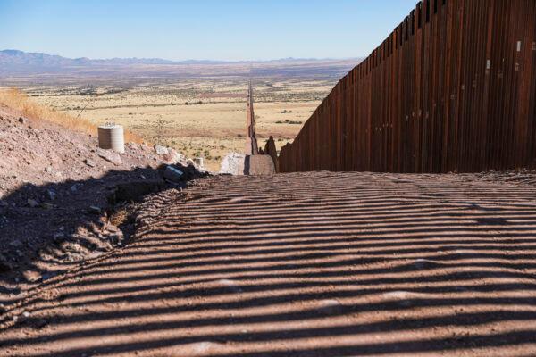 The border wall’s accompanying road, lights, cameras, and sensors remain unfinished since January 2021 when President Joe Biden halted all border wall construction, in Cochise County, Ariz., on Dec. 6, 2021. (Charlotte Cuthbertson/The Epoch Times)