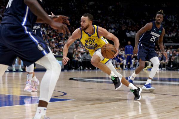 Stephen Curry #30 of the Golden State Warriors drives to the basket against Reggie Bullock #25 of the Dallas Mavericks in the third quarter at American Airlines Center, in Dallas, on Jan. 5, 2022. (Tom Pennington/Getty Images)