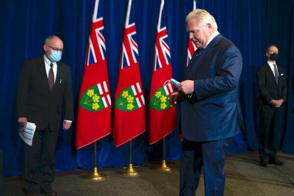 Ontario Premier Doug Ford attends a news conference with chief medical officer of health Dr. Kieran Moore (L) and Finance Minister Peter Bethlenfalvy in Toronto on Jan. 3, 2022. (The Canadian Press/Chris Young)