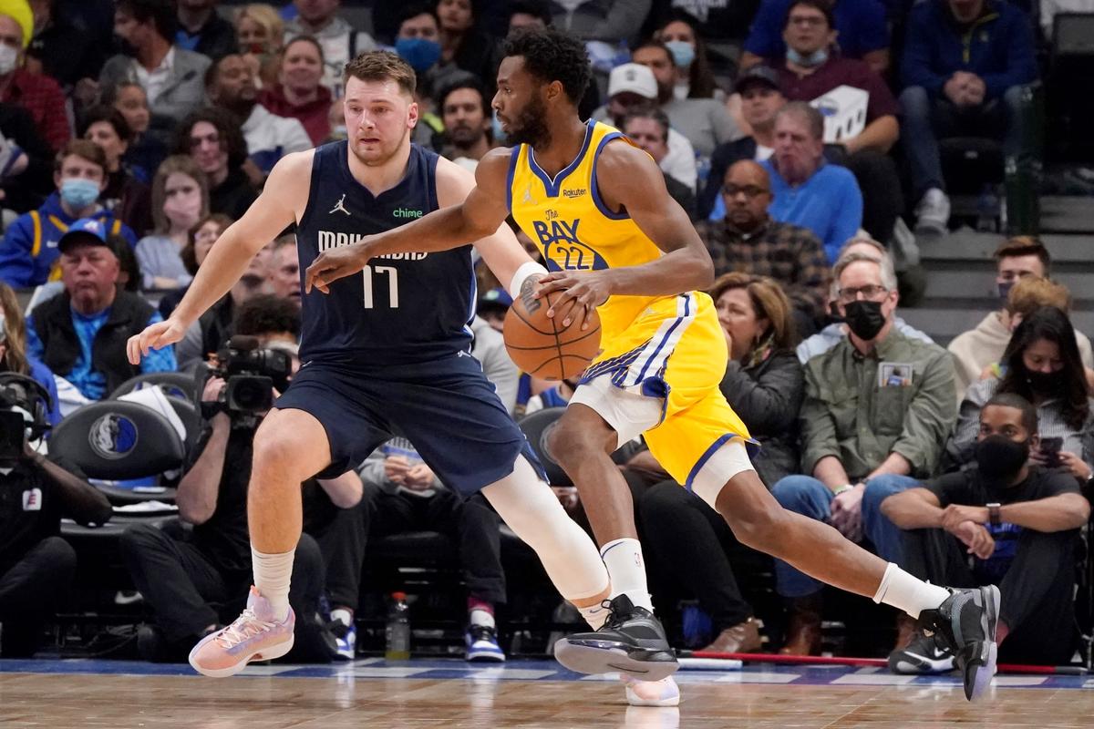 Golden State Warriors forward Andrew Wiggins (22) drives against Dallas Mavericks guard Luka Doncic (77) during the first quarter of an NBA basketball game in Dallas, on Jan. 5, 2022. (LM Otero/AP Photo)