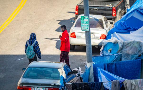 Men walk near a homeless encampment in downtown Los Angeles on Jan. 6, 2022. (John Fredricks/The Epoch Times)