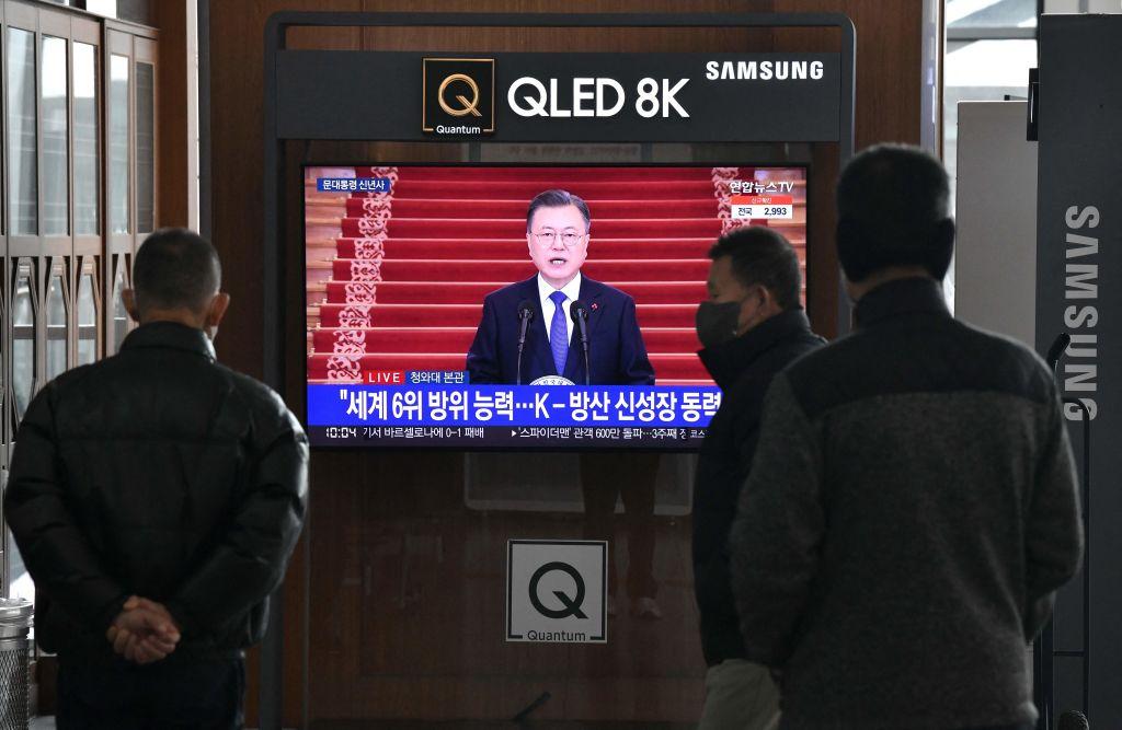 People watch a television news program broadcasting live footage of South Korean President Moon Jae-in delivering a New Year's speech, at a railway station in Seoul on January 3, 2022. (Photo by Jung Yeon-je / AFP via Getty Images)