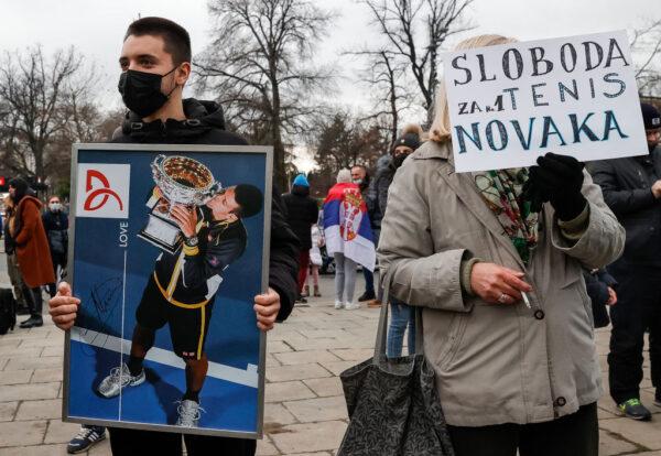  Demonstrators pose with a placard picturing Serbian tennis player Novak Djokovic as they participate in a rally in front of Serbia's National Assembly as World No.1 tennis player Novak Djokovic fights deportation from Australia after his visa was cancelled on January 6, 2022, in Belgrade, Serbia. (Srdjan Stevanovic/Getty Images)