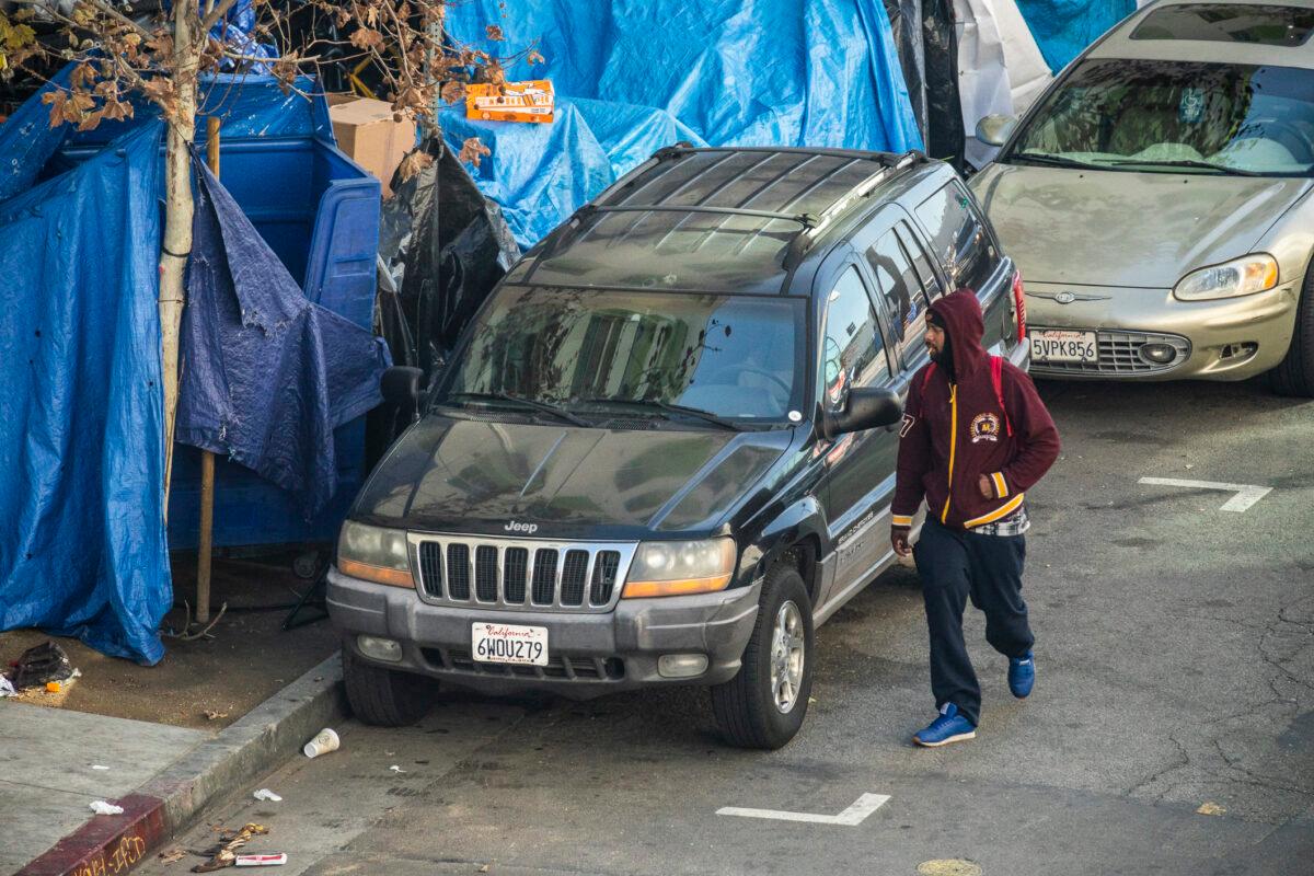 A man walks past a homeless encampment in Los Angeles, Calif., on Jan 6, 2022. (John Fredricks/The Epoch Times)
