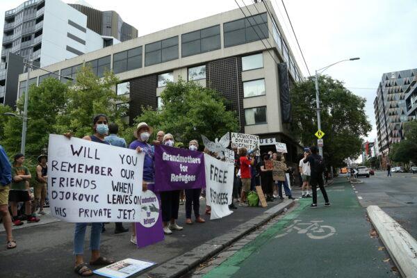Protestors gather outside an immigration detention hotel where Serbia's Novak Djokovic is believed to stay, in Melbourne, Australia, on Jan. 7, 2022. (Hamish Blair/AP Photo)