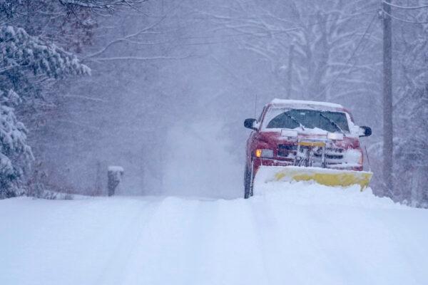 A small truck removes snow from an unplowed road in East Derry, N.H., on Jan. 7, 2022. (Charles Krupa/AP Photo)