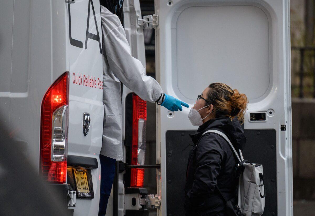 A person receives a Covid-19 test out of a mobile testing van in New York City on Jan. 5, 2022. (Angela Weiss/AFP via Getty Images)