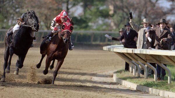 "Red" Pollard (Tobey Maguire) wearing red silks and riding Seabiscuit, in "Seabiscuit." (DreamWorks Pictures)