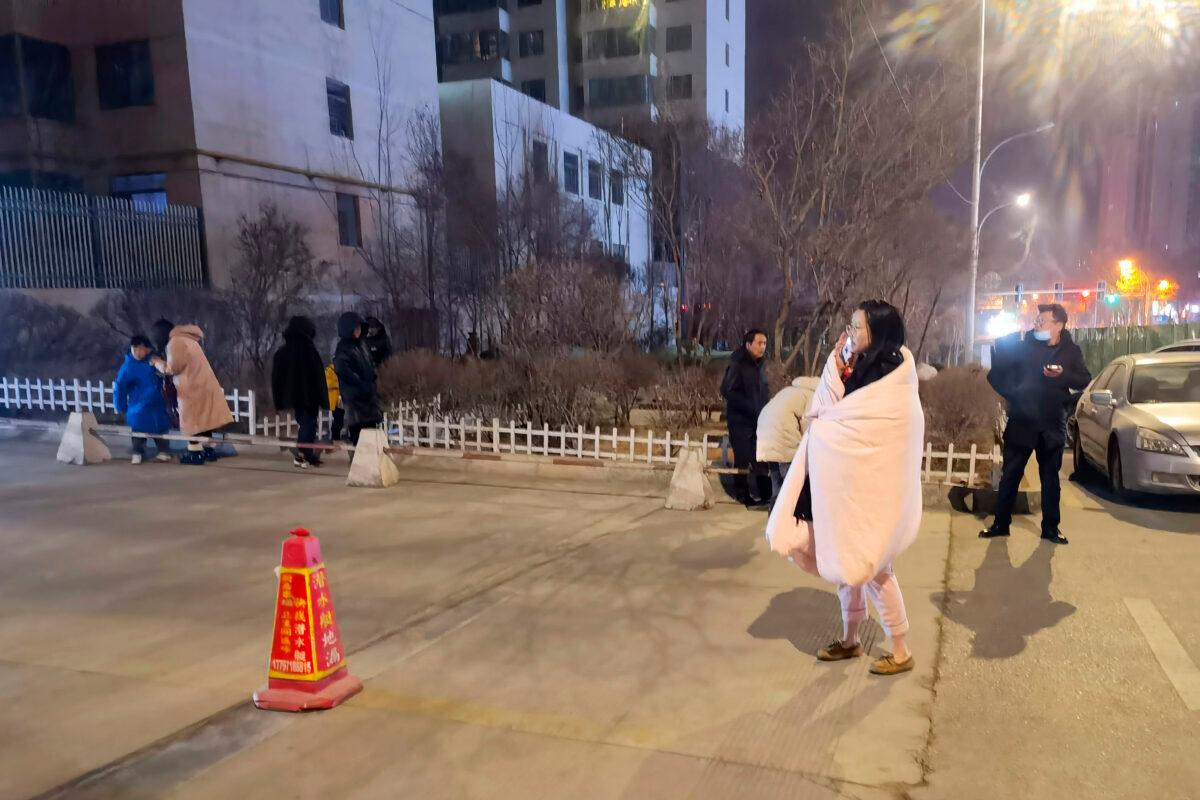 People stand on the street after an earthquake in Xining in northwestern China's Qinghai Province, on Jan. 8, 2022. (Wang Bo/Xinhua via AP)