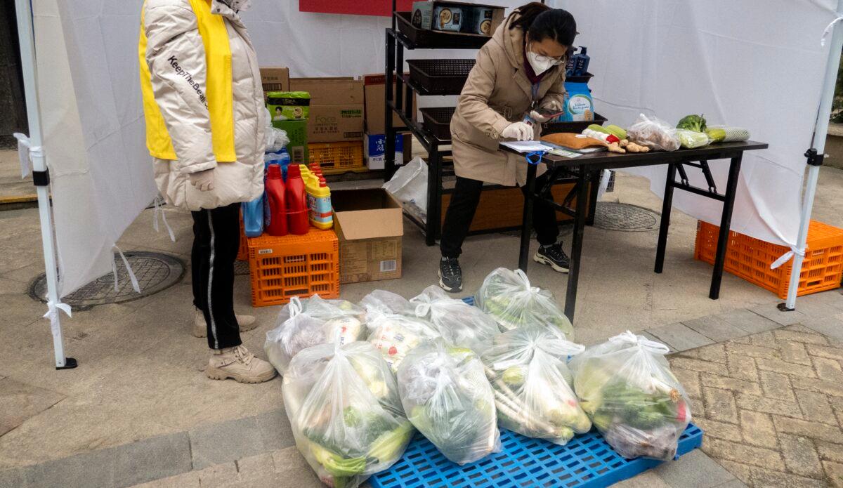 The staff members sell food in a residential compound in Xi'an, in northwestern China’s Shaanxi Province on Jan. 6, 2021. (STR/AFP via Getty Images)