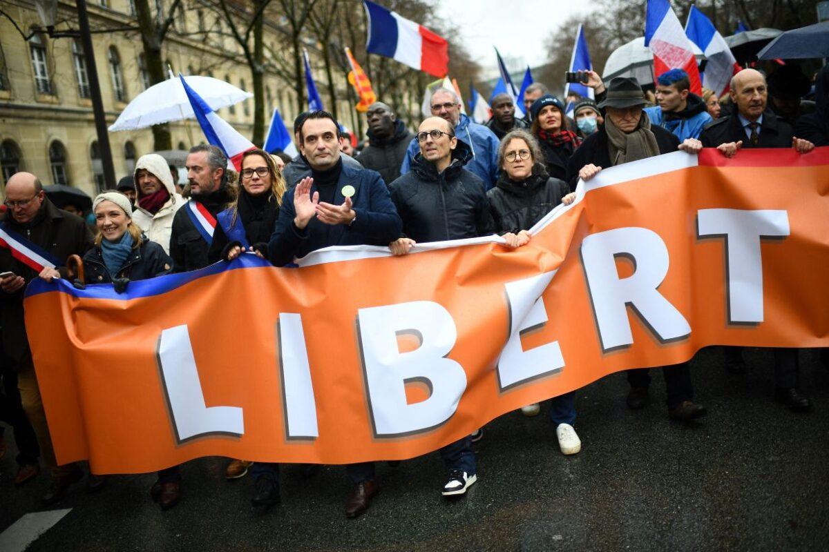 French party Les Patriotes leader Florian Philippot (C) and lawyer Fabrice di Vizio (4th R) march during a rally called by his party against the compulsory COVID-19 vaccination and the mandatory use of the health pass, in Paris on Jan. 8, 2022. (Christophe Archambault/AFP via Getty Images)