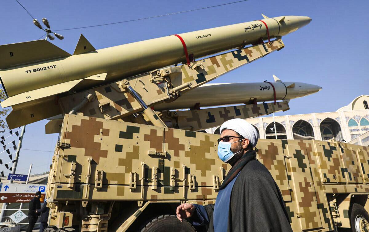 A cleric walks past Zolfaghar, top, and Dezful missiles in Tehran, Iran, on Jan. 7, 2022. (Vahid Salemi/AP Photo)