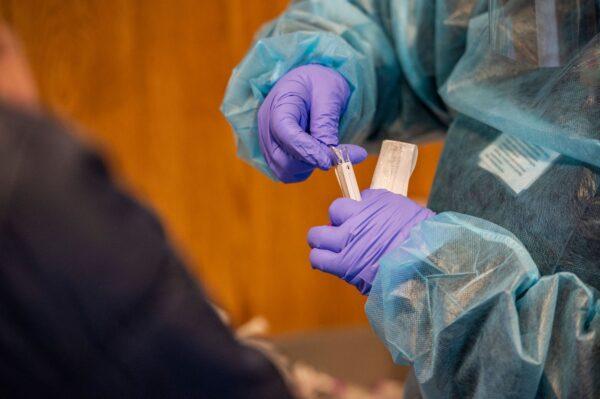 A medical worker places a nasal swab into a test tube after performing a PCR test for COVID-19 at East Boston Neighborhood Health Center in Boston, on Dec. 20, 2021. (Joseph Prezioso/AFPvia Getty Images)
