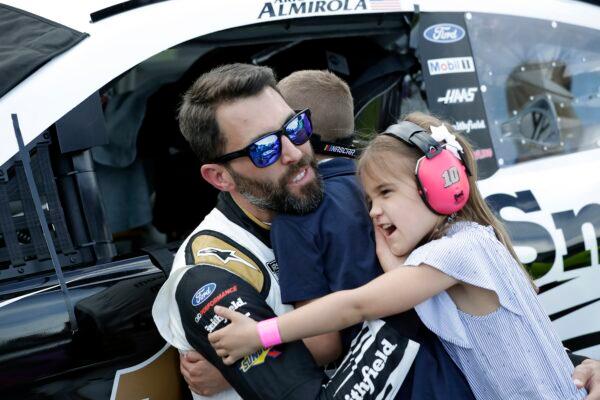 Aric Almirola (L) hugs his children Alex (C)  and Abby (R) at Daytona International Speedway, in Daytona Beach, Fla. on Feb. 16, 2020. (John Raoux/AP Photo)