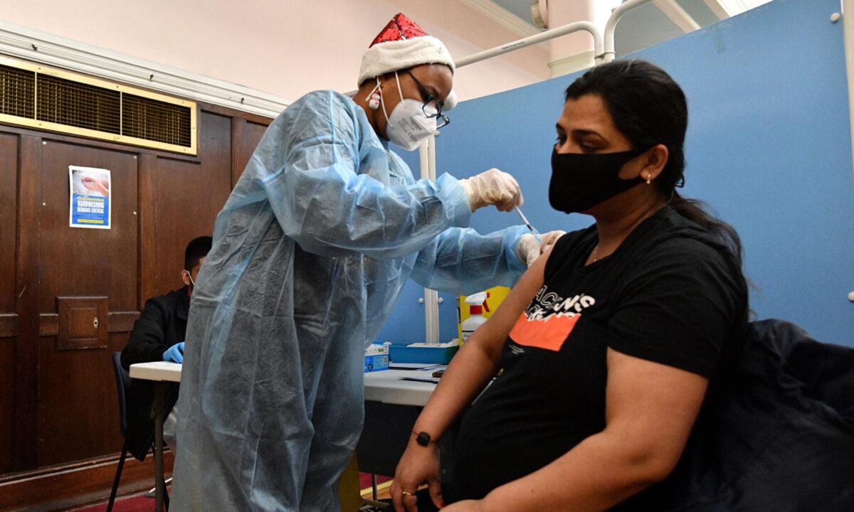 A health worker administers a dose of a CCP virus vaccine to a pregnant woman at a pop-up vaccination centre at the Redbridge Town Hall, east London, on Dec. 25, 2021. (Justin Tallis/AFP via Getty Images)