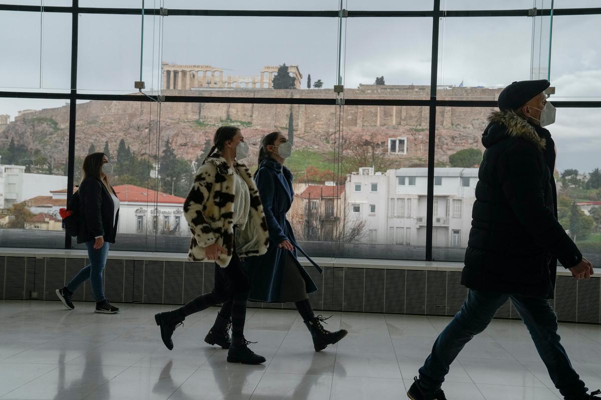 People visit the Acropolis Museum, with the ancient Parthenon temple in the background, in Athens, on Jan. 10, 2022. (Thanassis Stavrakis/AP Photo)