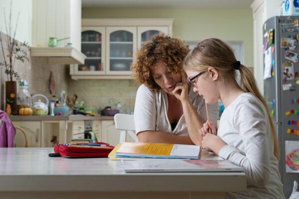 A mother helping her child with homework. (KaliAntye/Shutterstock)