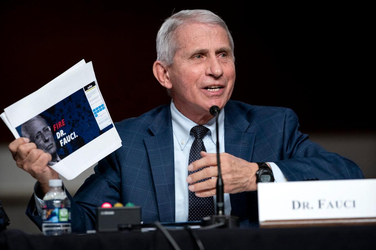 Dr. Anthony Fauci, White House chief medical advisor and director of the NIAID, shows a screengrab of a campaign website for Sen. Rand Paul (R-Ky.) while answering questions at a Senate Health, Education, Labor, and Pensions Committee hearing on Capitol Hill on Jan. 11, 2022. (Greg Nash-Pool/Getty Images)