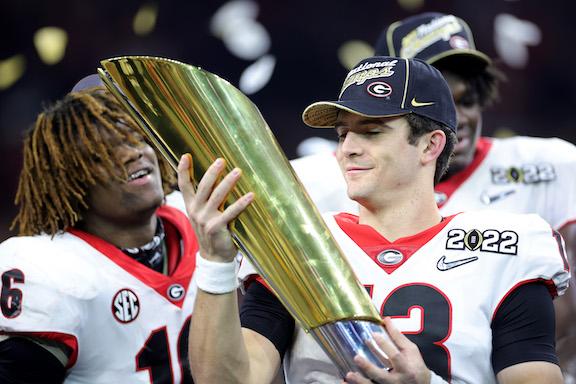 Stetson Bennett #13 of the Georgia Bulldogs celebrates with the National Championship trophy after the Georgia Bulldogs defeated the Alabama Crimson Tide 33-18 during the 2022 CFP National Championship Game at Lucas Oil Stadium, in Indianapolis, on January 10, 2022. (Carmen Mandato/Getty Images)