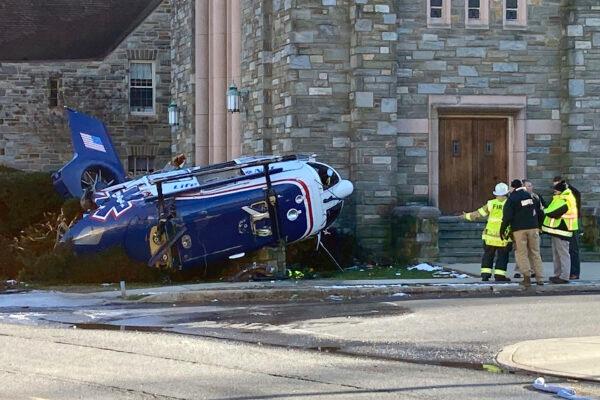 Firefighters from Upper Darby, Pa., stand near a medical helicopter that crashed next to a church in a residential area of suburban Philadelphia, on Jan. 11, 2022. (Claudia Lauer/AP Photo)