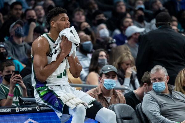 Milwaukee Bucks forward Giannis Antetokounmpo (34) sits on the scorer’s table during a timeout during the first half of an NBA basketball game against the Charlotte Hornets in Charlotte, N.C, on Jan. 8, 2022. (Matt Kelley/AP Photo)