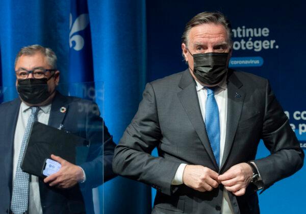 Quebec Premier Francois Legault (L) and then-Public Health Director Horacio Arruda leave a news conference in Montreal on Dec. 30, 2021. (The Canadian Press/Graham Hughes)