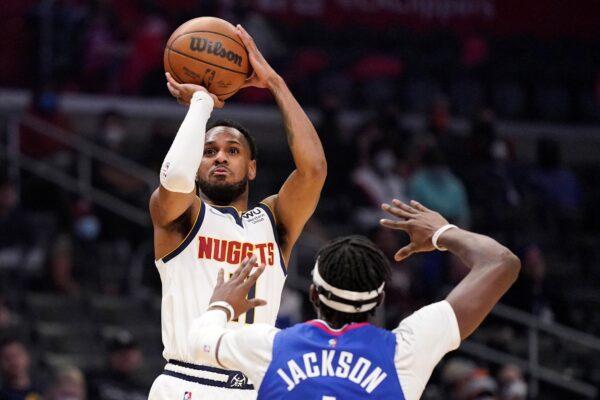 Denver Nuggets guard Monte Morris, left, shoots as Los Angeles Clippers guard Reggie Jackson defends during the first half of an NBA basketball game in Los Angeles, on Jan. 11, 2022. (Mark J. Terrill/AP Photo)