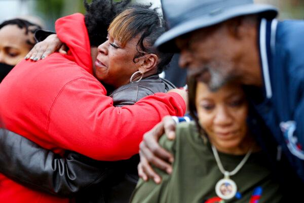Friends and family of slain rapper, Young Dolph, hug after a street naming ceremony honoring Young Dolph in Memphis, Tenn., on Dec. 15, 2021. (Patrick Lantrip/Daily Memphian via AP)