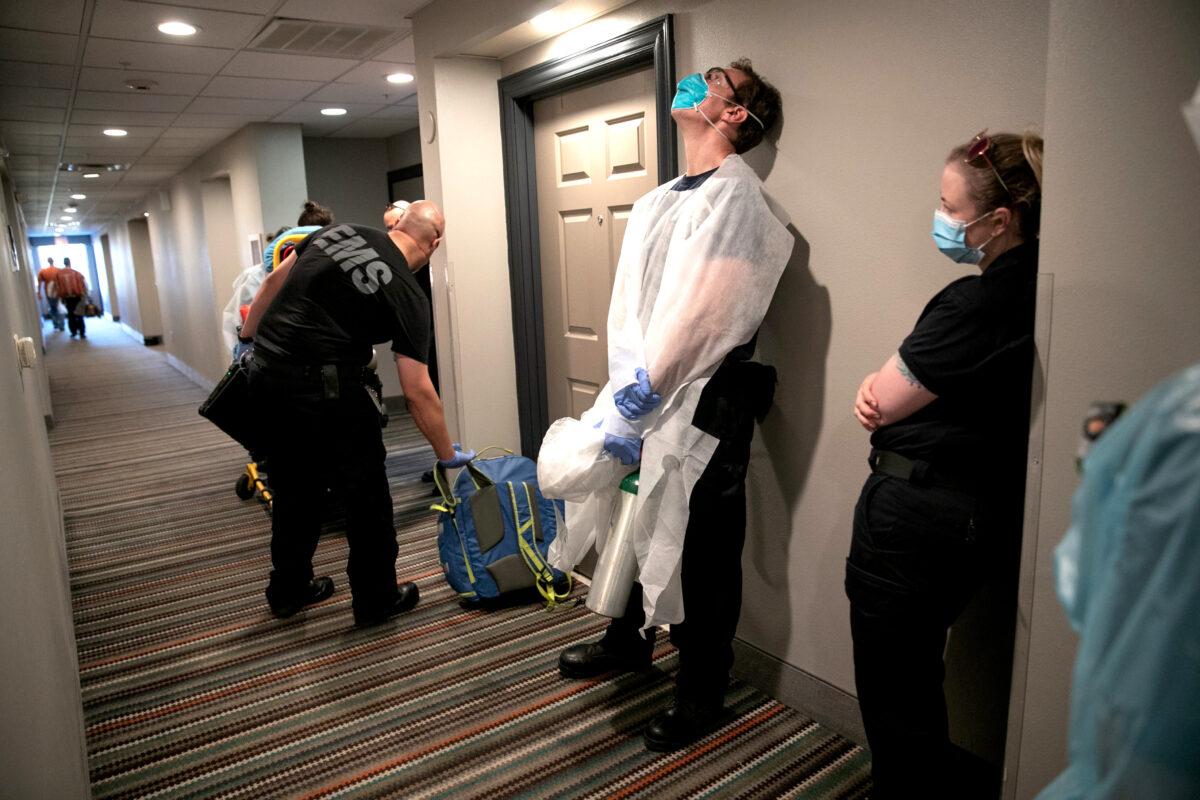 Medics wait to transport a woman with possible COVID-19 symptoms to the hospital in Austin, Texas, on Aug. 7, 2020. (John Moore/Getty Images)