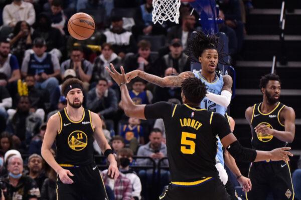 Ja Morant #12 of the Memphis Grizzlies passes against Kevon Looney #5 of the Golden State Warriors during the first half at FedExForum in Memphis, on Jan. 11, 2022. (Justin Ford/Getty Images)